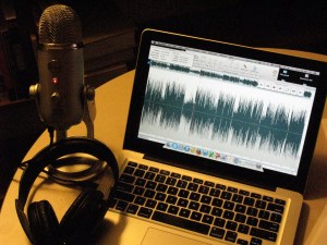 A computer, a microphone, and earphones: all you need to record a podcast.