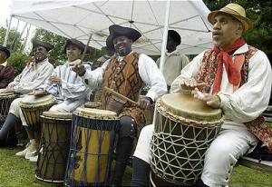 African american men wearing colonial tricorn hats and playing west African drums.