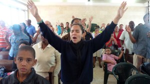 Congregation with hands raised in song.