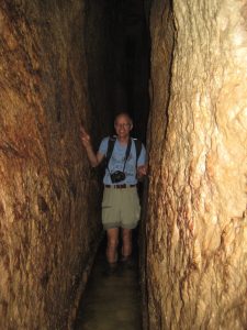 The author in a narrow stone tunnel with water up to his knees.