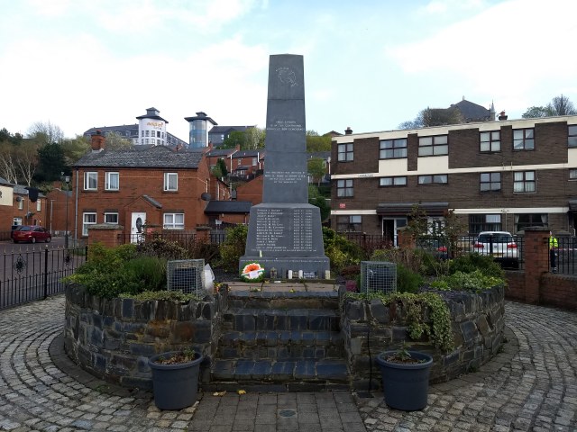 Memorial plinth with flowers and wreaths.